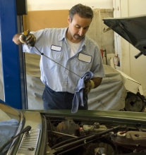Image of mechanic checking oil levels inside of a vehicle