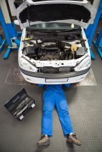 Image of mechanic legs poking out from beneath a vehicle