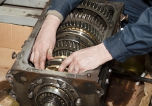 Image of mechanic with hands inside of an engine