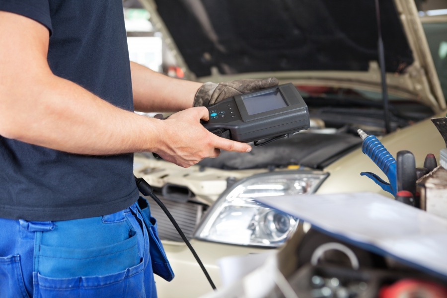 Image of mechanic measuring battery life on a vehicle