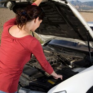 woman looking under vehicle hood