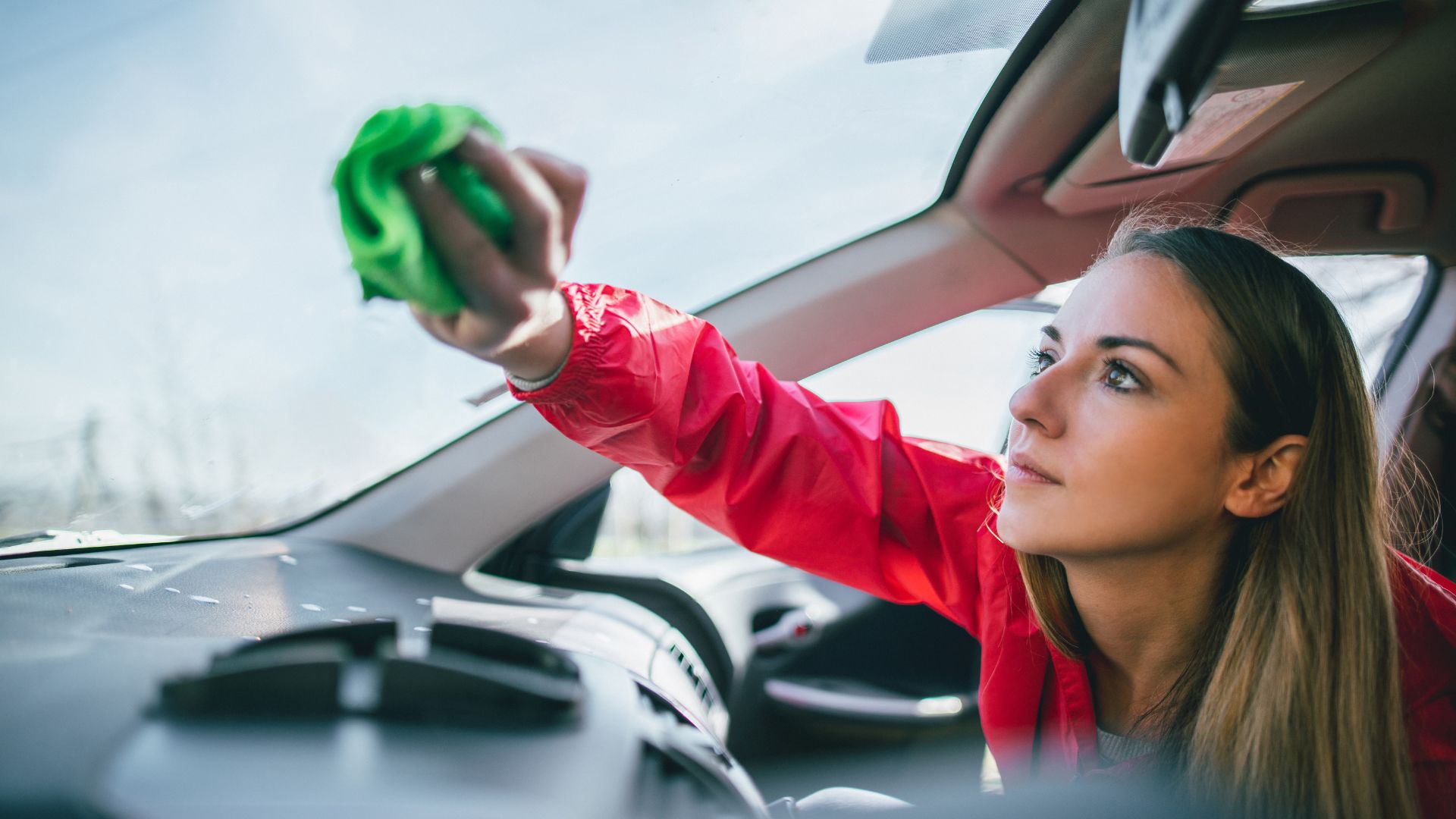 person cleaning car windshield