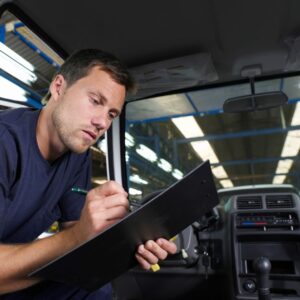 professional inspecting car while holding clipboard