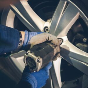 person removing bolts for car tires