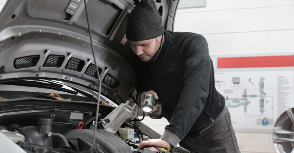 man working under hood of car