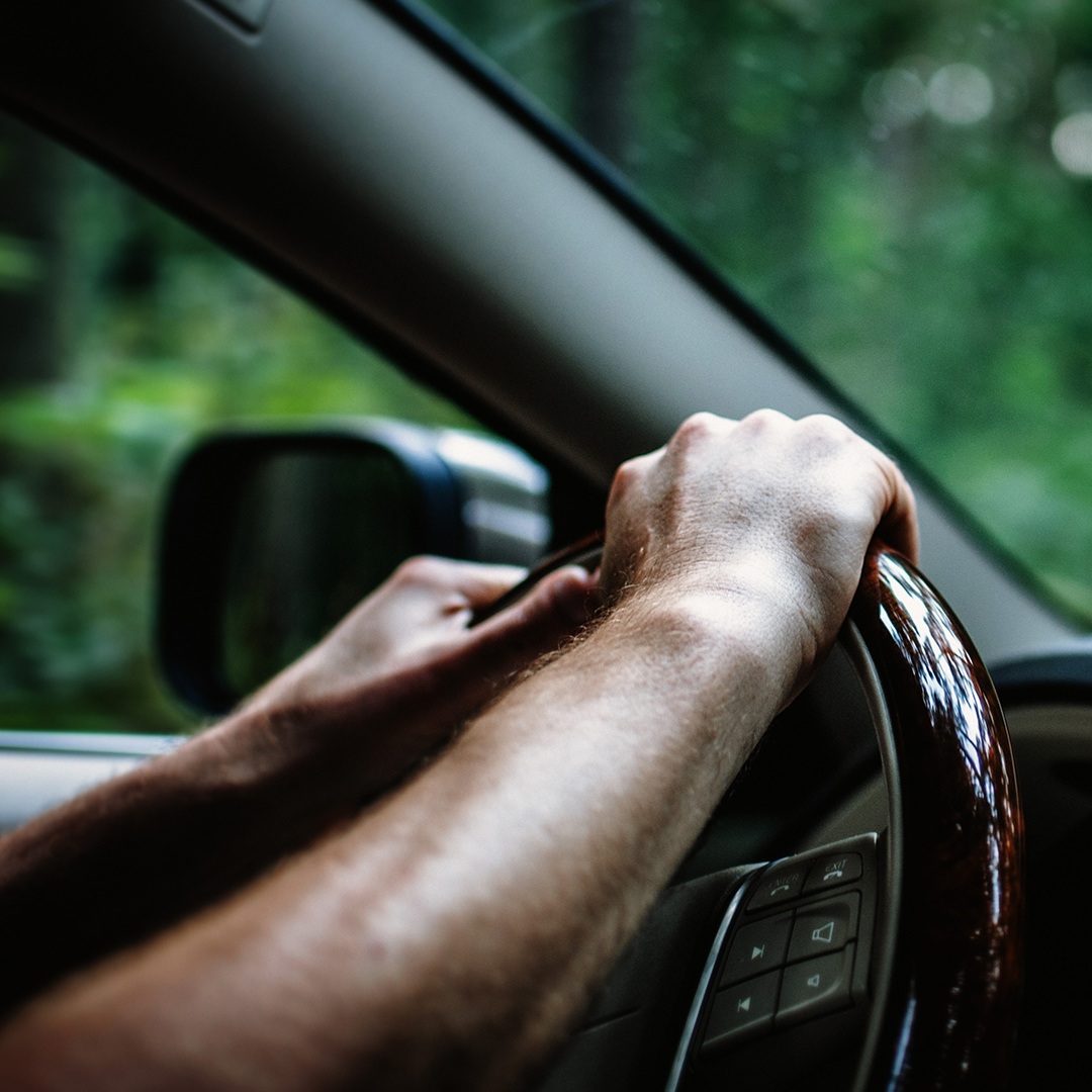 A car is pulling to one side while the driver firmly holds the steering wheel.

