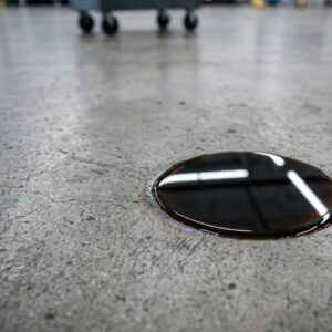 A puddle of fluid on a garage floor indicating a vehicle leak.